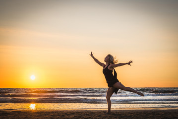 Fototapeta na wymiar Silhouette of a happy beautiful dancer girl at sunset