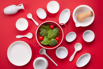 White tableware and kitchen utensils over the reg backgtound. Mockup, cooking blog, classes concept