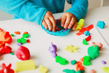 Child playing with clay molding shapes