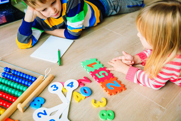 little boy and girl learn to write and calculate numbers