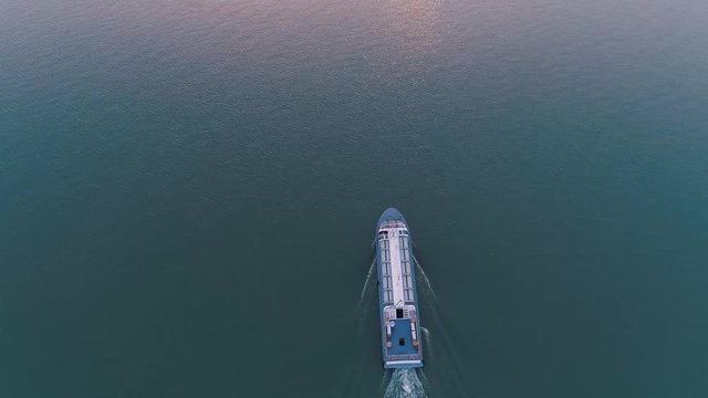 Aerial drone view of pleasure boat sails on the lake on sunset