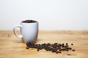 Coffee symbol image with text space and lots of dark roasted cofee arabica beans on wood