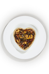 Cute and tasty heart shaped sweet pie on an isolated plate made with love