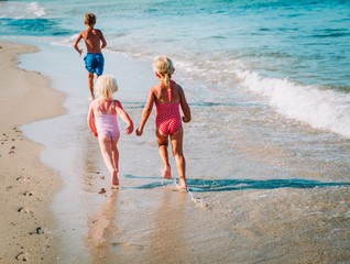 Naklejka premium little boy and girls run play at beach