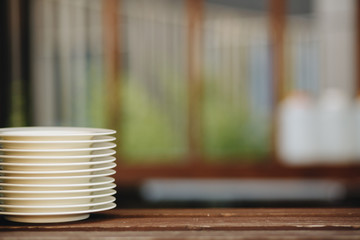 a stack of clean white plates on an outdoor table.
