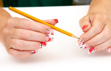 female hands with manicure and pencil 