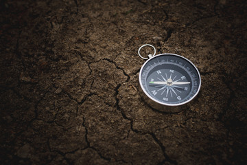 Fototapeta na wymiar compass on cracked soil. - vintage style