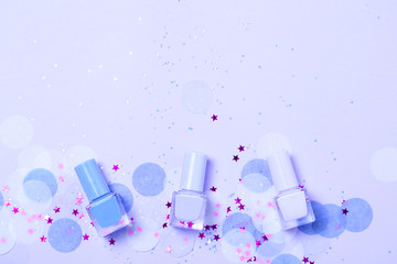 Pastel blue nail polishes and confetti, stars and sparkles.