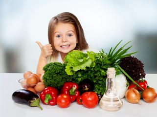 Fototapeta na wymiar Beautiful girl with colored vegetables showing thumbs