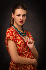 Beautiful female brunette model in handmade accessories fashion jewelry necklace.