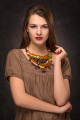 Naklejka premium Beautiful female brunette model in handmade accessories fashion jewelry necklace.