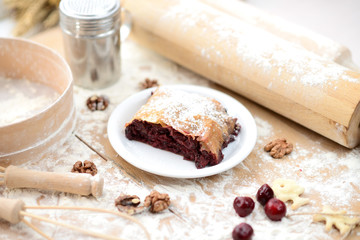 strudel (roll strudel) with cherry on a wooden board with flour
