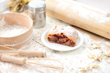 Fototapeta na wymiar strudel (roll strudel) plum on a wooden board with flour