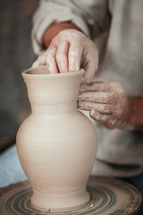 hands of a potter, creating an earthen jar on the circle 