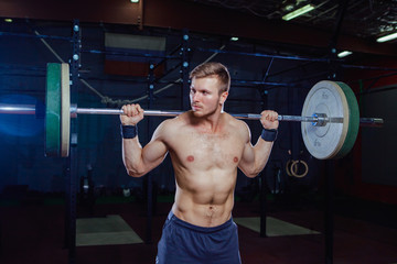 Fototapeta na wymiar Muscular fitness man preparing to deadlift a barbell over his head in modern fitness center.Functional training.Snatch exercise. Cross style fit, deadlift