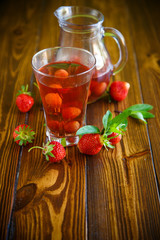 Sweet compote of ripe red strawberries in a glass decanter