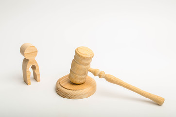 A wooden figure of a man with a void in the shape of a child near the hammer of a judge. The...