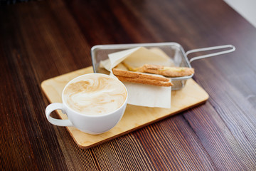Cup of cappuccino and a sandwich.