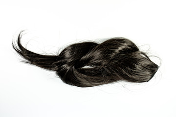 Black long hair extension laying on a white counter waiting to be applied.