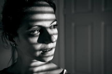 Fototapeta na wymiar Depressed young woman near window at home, closeup