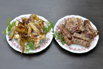 steak and chevachchi with a grill in a plate with parsley plate with grilled wings on a gray background table.