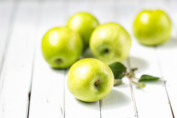 green apples on a light wooden background .fruit, health