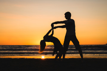 Beautiful silhouettes of dancers at sunset