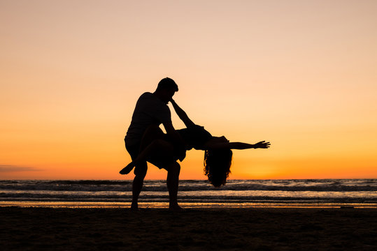 Beautiful silhouettes of dancers at sunset