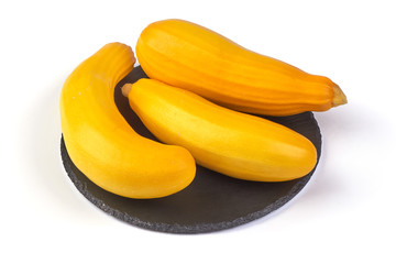 Yellow zucchini squash on the shale board, isolated on white background.