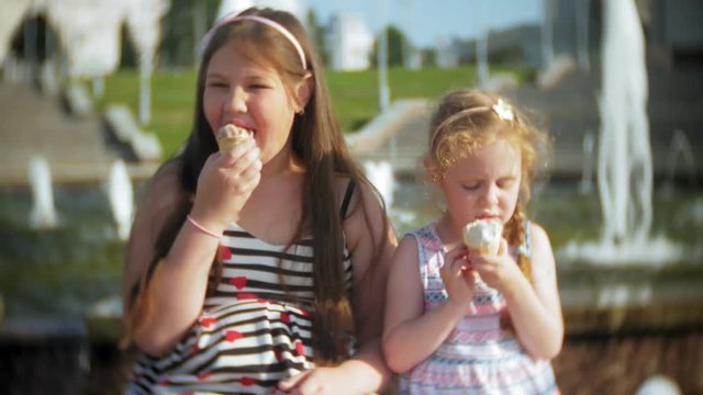Child, Little Girl Eating Ice Cream on a Hot, Torrid Summer Day, Children near the fountain