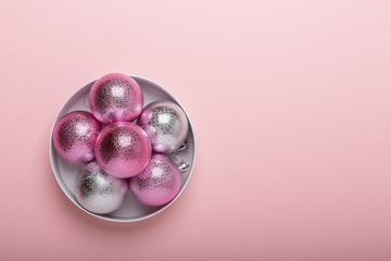 Pink and silver christmas balls on a paper background. Top view, flat lay, copy space