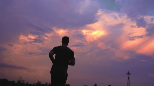 muskul&ouml;ser Mann joggt dem Sonnenuntergang entgegen