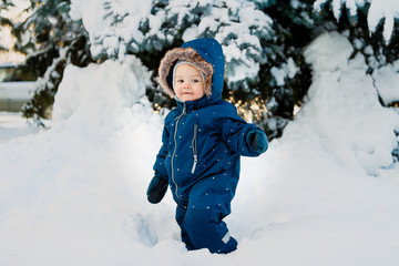 Fototapeta na wymiar winter. January walks on snowdrifts. The child walks through snow-covered streets in any weather