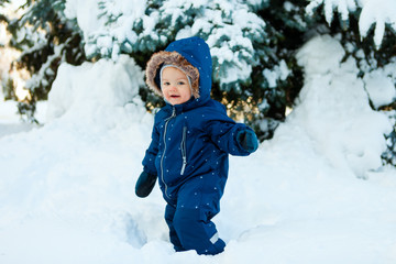 Fototapeta na wymiar winter. New Year and Christmas holidays. the child walks on snow in a warm winter overall.