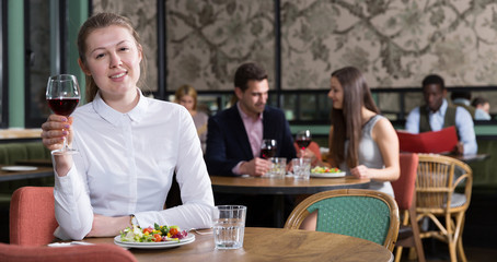 Smiling young woman alone in restaurant