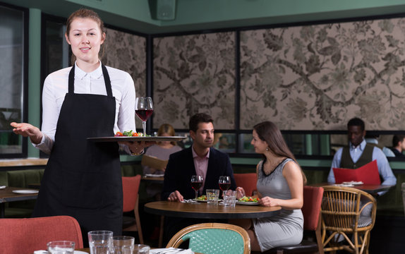 Smiling waitress with serving tray