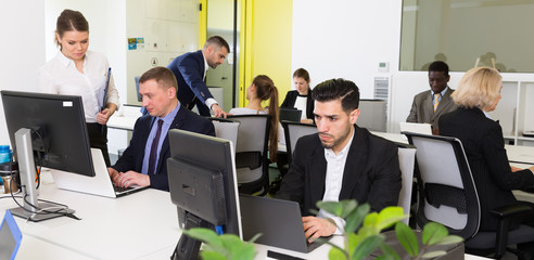 Business people working in open plan office