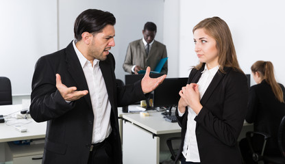 Angry man boss pointinting to misses in work to female