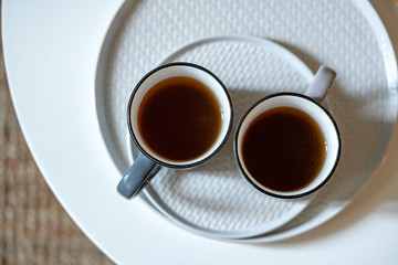 Two mugs of tea on a table on ceramic white round plates. FlatLAy