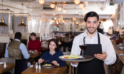 Fototapeta na wymiar Smiling waiter with serving tray