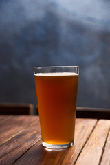 Glass of light beer on the wooden table