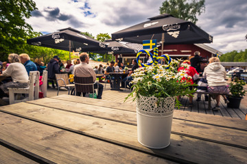 Swedish Archipelago - June 23, 2018: Vase in a table in a Midsummer gathering in the island of Moja in the Swedish Archipelago during Midsummer, Sweden - obrazy, fototapety, plakaty