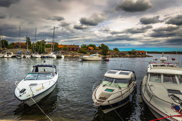 Fototapeta na wymiar Swedish Archipelago - June 23, 2018: Boats in the harbor in the island of Moja in the Swedish Archipelago during Midsummer, Sweden