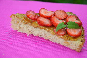 photo of delicious tasty strawberry sandwich. a sandwich with strawberries and peanut butterflies on a crimson background. top view, copy space. a healthy snack