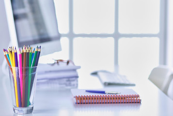 Graphite pencils in a glass grid-container on the office table.