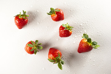 Fresh red isolated strawberry fruits with dew drops on them on a white background