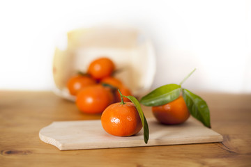 Orange mandarin fruits in wood basket on counter with leafs for healthy nutriotion with vitramin c