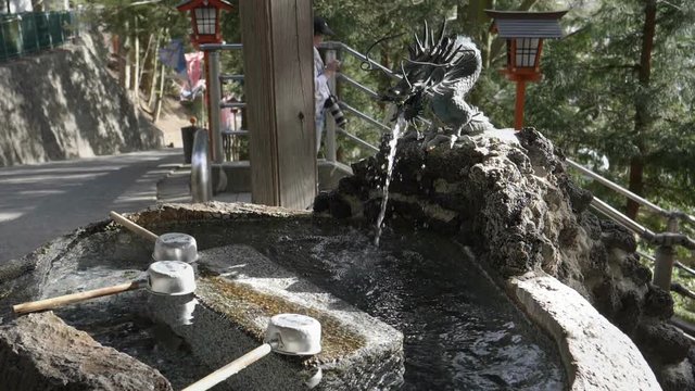 180p slow motion wide shot of a purification fountain at arakura sengen shrine in japan