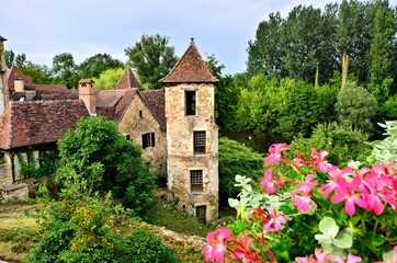 Fototapeta na wymiar Old medieval house and tower with flowers in the quaint village of Carennac, France