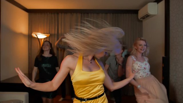 Blondie woman party dancer. Sexy pretty cheerful blond female dancing on dance floor. Her friends also jumping with music. Slow motion. 4k
